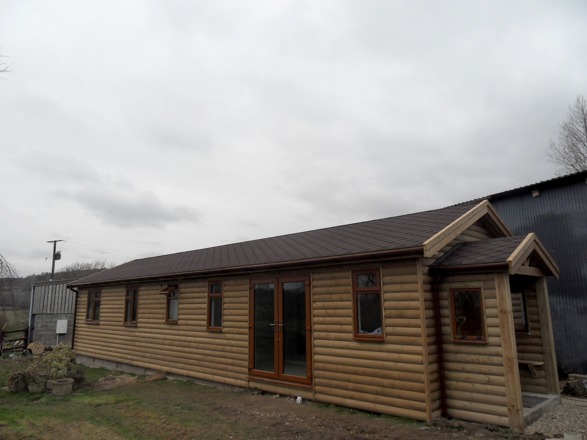  A beautiful Loglap two bedroom Chalet, complete with kitchen, bathroom and sitting room, fully partitioned, insulated and plaster boarded. The roof covering is felt shingled - Harris Timber Products